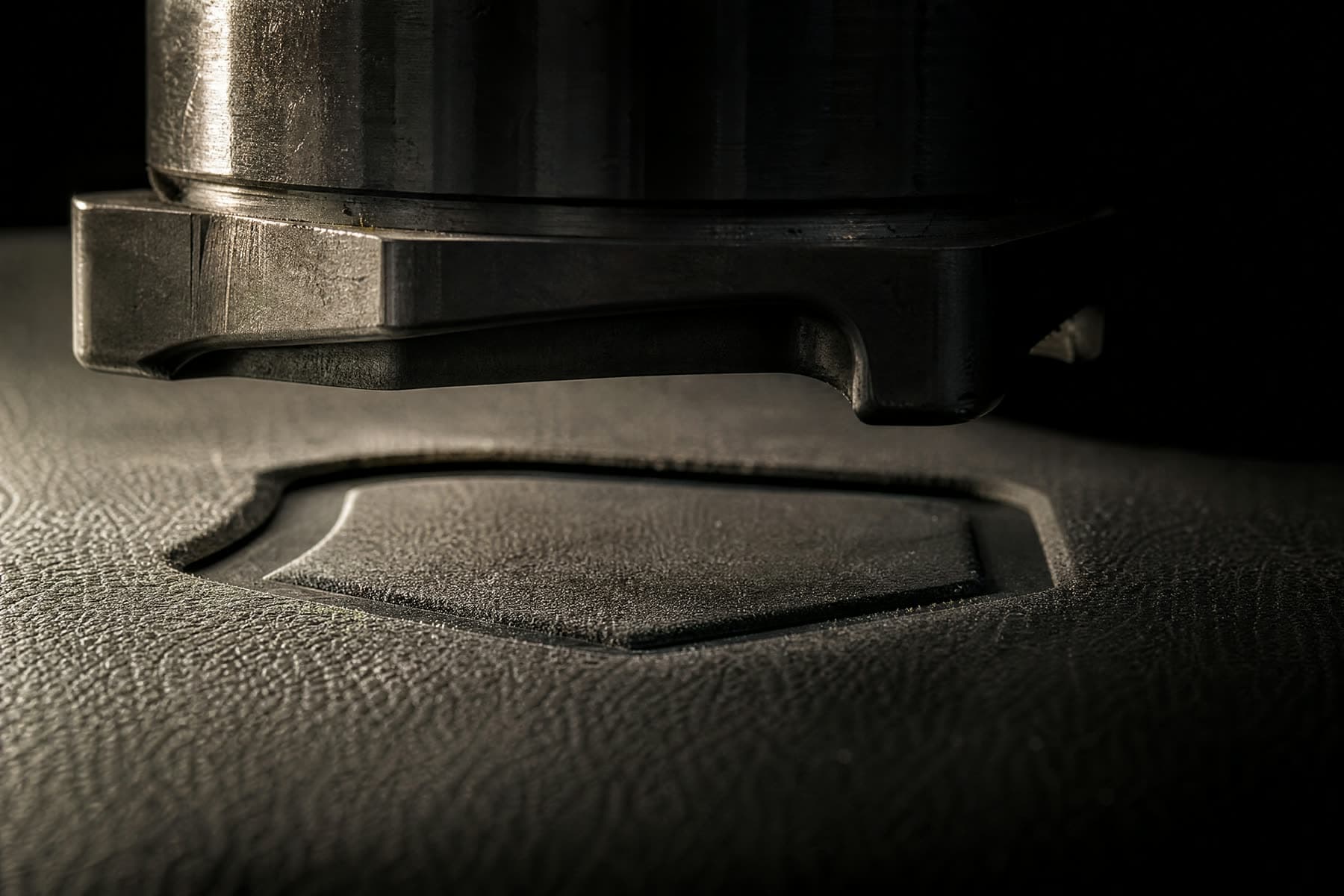 A steel die pressing a blind impression into leather