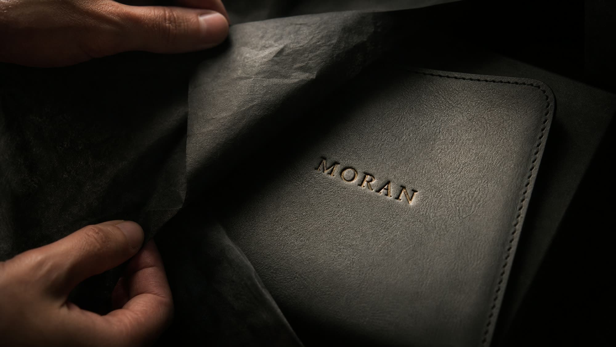 Tissue folded back from a leather panel to reveal an engraved name